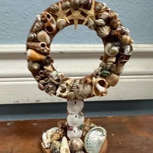 Round wooden picture frame decorated with shells